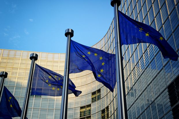 Several EU flags in front of the European Commission building in Brussels