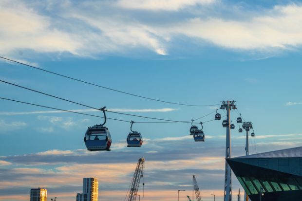 Modern Cable Car System Soaring Above the City Skyline at Sunset in Greenwich, London Modern Cable Car System Soaring Above the City Skyline at Sunset in Greenwich, London