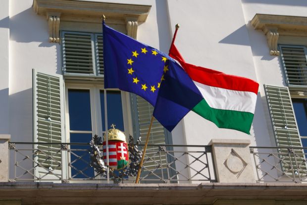 Hungary and EU flags perched outside a balcony