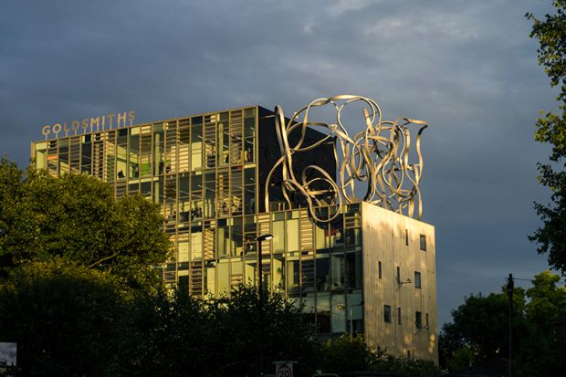 Goldsmiths, University of London, in New Cross, London bathed in dramatic yellow sunlight with a cloudy sky.