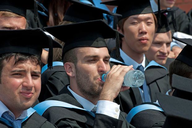 A graduation ceremony with a graduate drinking water and looking hot, UK. To illustrate that dealing with extreme heat is ‘hugely problematic’ for universities. A graduation ceremony with a graduate drinking water and looking hot, UK. To illustrate that dealing with extreme heat is ‘hugely problematic’ for universities.