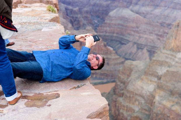 Grand Canyon - February 19 Tourist and visitors taking pictures at Eagle Point at Grand Canyon West Rim, AZ. Fatal falls while taking a pictures are one of the reason people die at Grand Canyon.