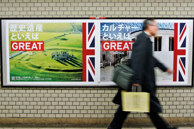 Pedestrian walks past 'GREAT' campaign posters Pedestrian walks past 'GREAT' campaign posters
