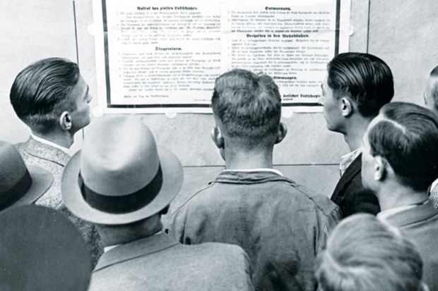 Group of men reading from notice board