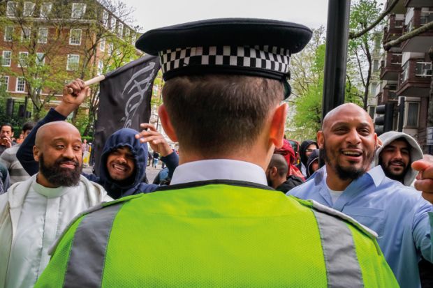 Group of muslim men and British police officer