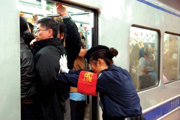 Guard pushes people onto train in Beijing