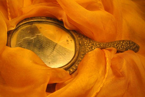 Handheld mirror laid on fabric Handheld mirror laid on fabric