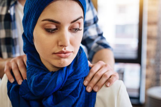 A Muslim woman with male hands on her shoulders A Muslim woman with male hands on her shoulders, signifying sexual harassment in the Middle East
