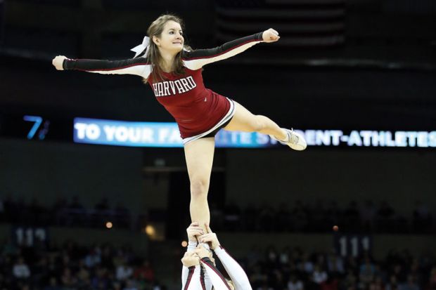 Harvard Crimson cheerleader (Harvard University) being held aloft