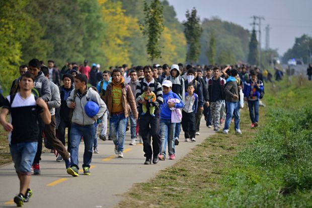 Hegyeshalom, Hungary - October 6, 2015 Group of refugees leaving Hungary. They came to Hegyeshalom by train and then they leaving Hungary and go to Austria and then to Germany. Many of them escapes from home because of civil war.