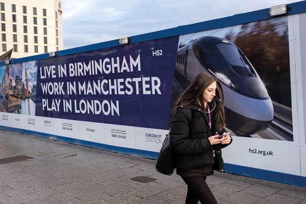 A woman walks in front of a billboard advertising HS2