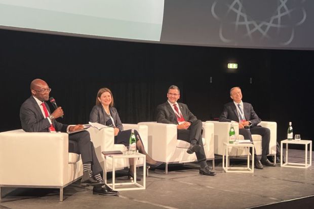 Four panelists sitting on a stage at the THE Europe summit 