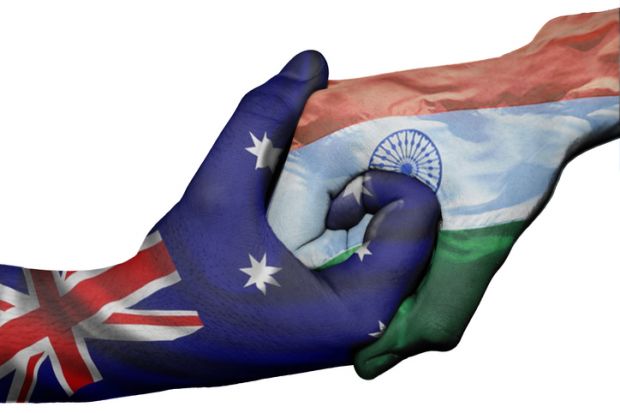 Hands with Australian and Indian flags locked together