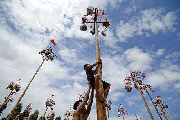 Participants climb greasy poles to collect prizes during celebrations for Indonesia’s 78th Independence Day in Jakarta, 17 August 2023