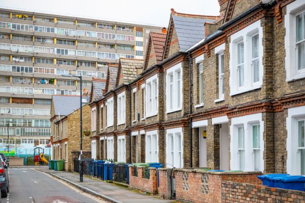 istock inequality Traditional English terraced houses with huge council block in the background