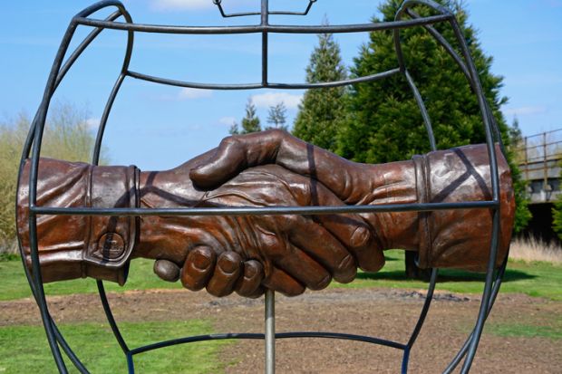 Christmas Truce Memorial showing soldiers handshake within a globe, National Memorial Arboretum, Alrewas, Staffordshire, England, UK