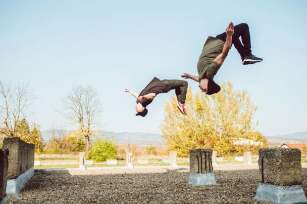 Two people perform backflips illustrating flipped classroom model