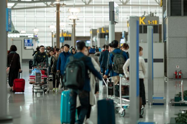 People with suitcases and luggage carts at Incheon International Airport. People with suitcases and luggage carts at Incheon International Airport.
