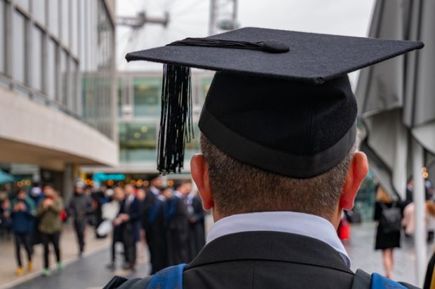  graduated student looking back to his colleagues and friends in University campus in London