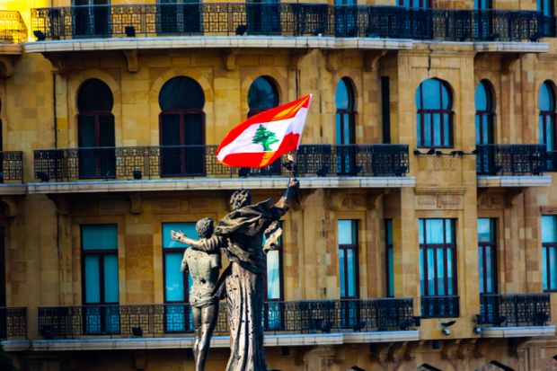 A statue of two people hugging with a Lebanese flag attached A statue of two people hugging with a Lebanese flag attached