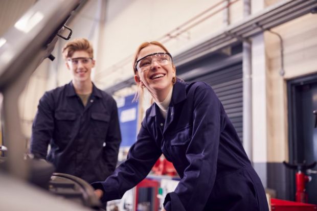 Students looking at car engine on auto mechanic apprenticeship course