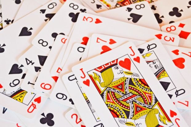 Playing cards randomly piled, with J on top