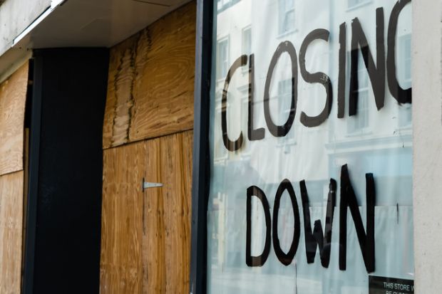 Closing down sign in a boarded-up shop window Closing down sign in a boarded-up shop window