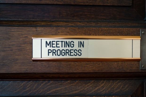 Close-up of sign on door saying 'Meeting in progress'