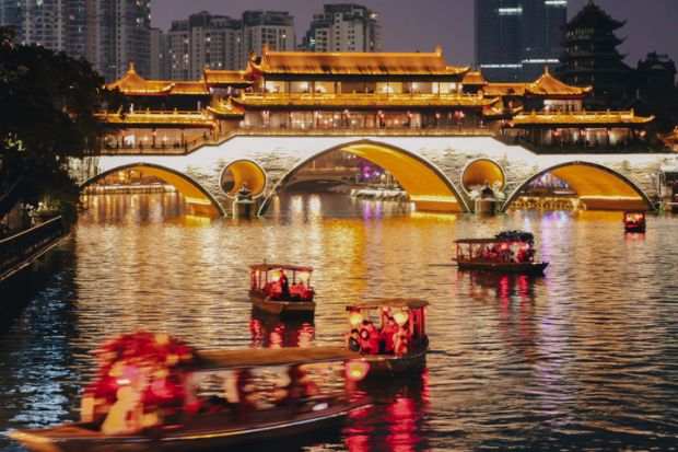  Stream of little tour boats on the Jinjiang River at night, passing the Anshun Bridge, in Chengdu, Sichuan, China