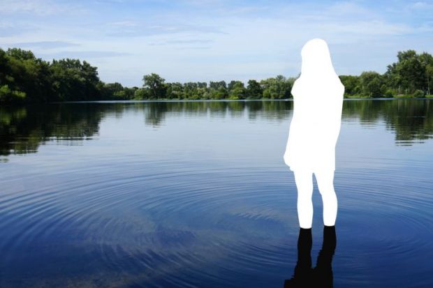 A whited out silhouette of a person stands in a lake