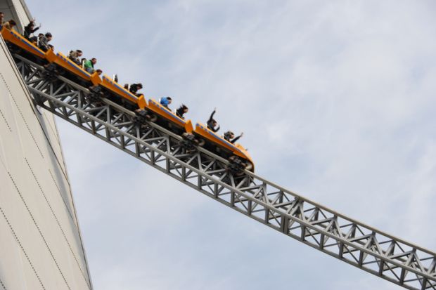 People riding rollercoaster at amusement park
