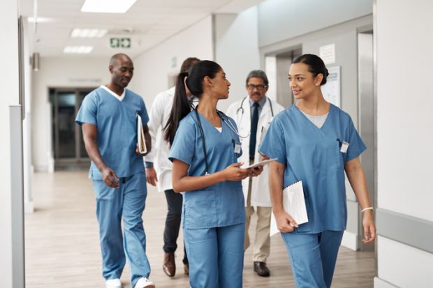 Doctors walking through hospital wearing scrubs