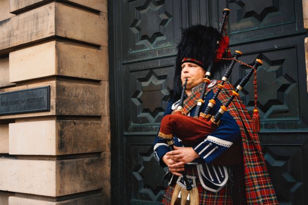 Closeup of a bagpipe street performer at the Royal Mile in Edinburgh