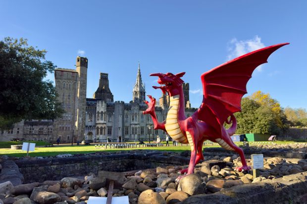 A red dragon in front of the Cardiff Castle and Victorian Gothic revival mansion in Cardiff, Wales.