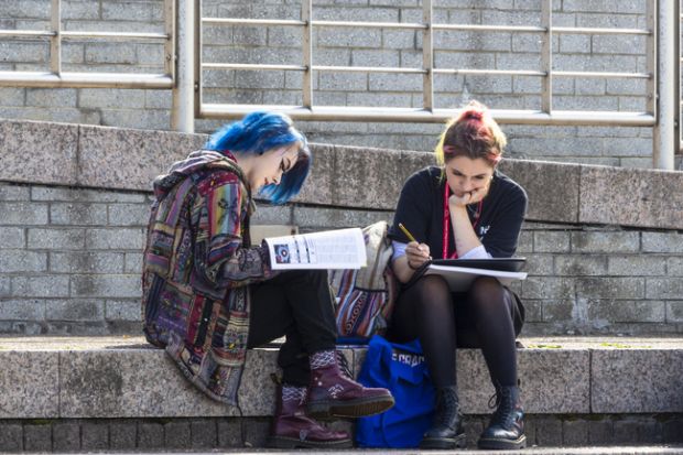 Two young female students studying outdoors.