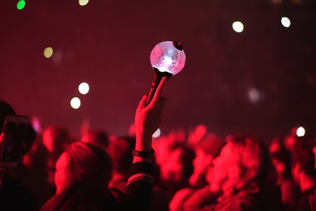 Kpop fan raises light stick lamp at a Kpop concert