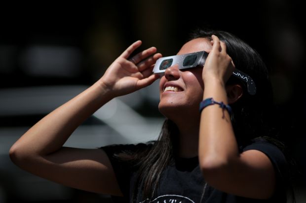 Girl watches solar eclipse