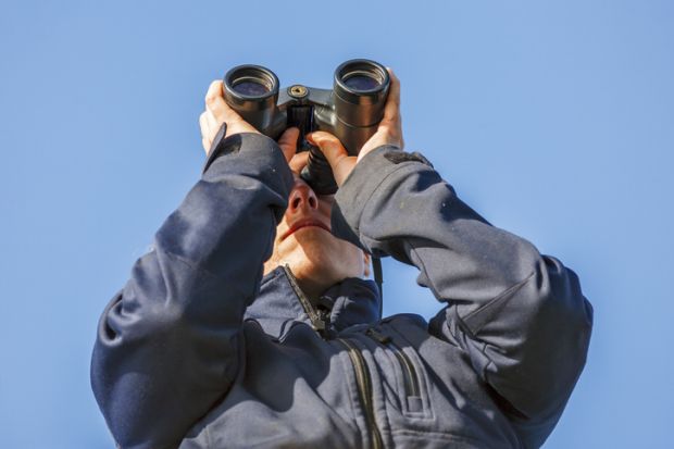 Young woman looking in binoculars