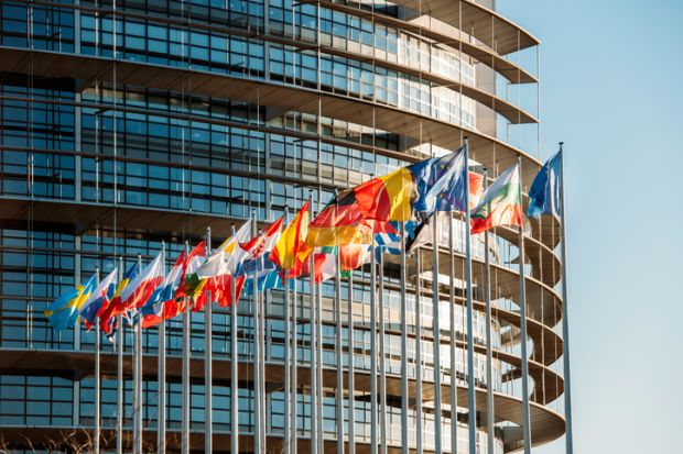 The European Parliament building in Strasbourg, France with flags waving on a spring evening