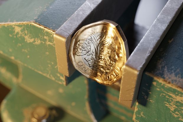 British pound coin squeezed by a bench vice