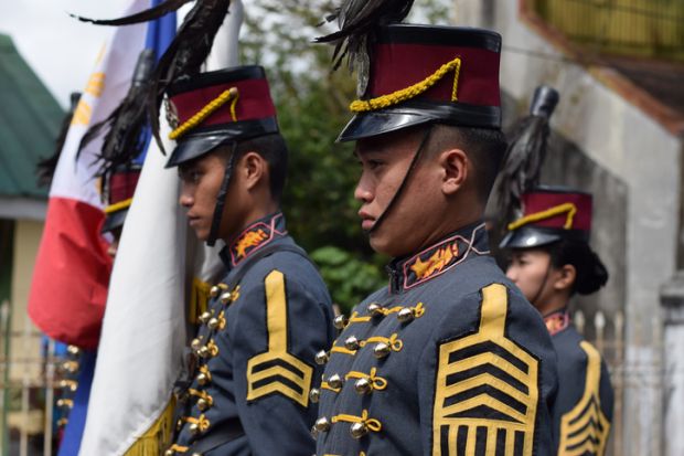 Male College military cadet on standing formation holding national flag. Male College military cadet on standing formation holding national flag.