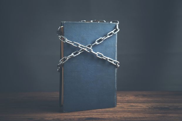 Blue book chained with lock on a wooden table