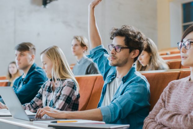 Student uses laptop while listening to a lecture at a university Student uses laptop while listening to a lecture at a university