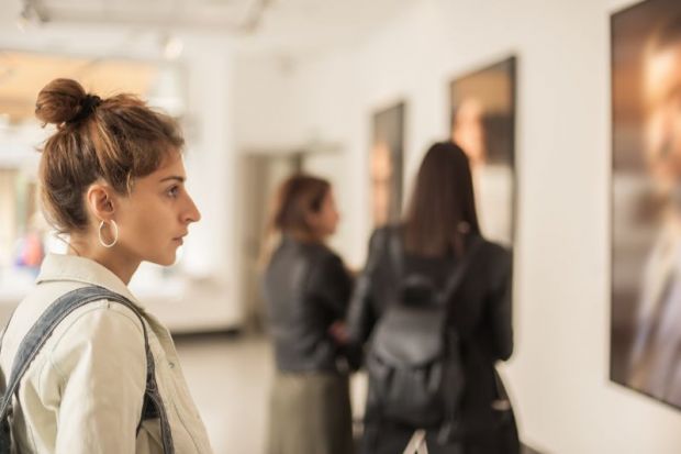 woman looking at painting in gallery