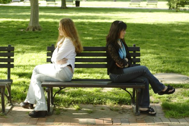 Two people facing away from each other on a bench