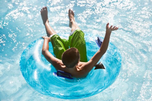 Student or teenager enjoying lazy river in rubber ring