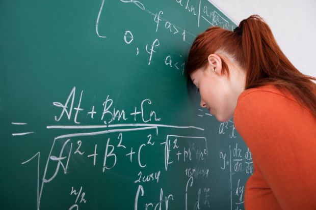 Student leaning head on blackboard