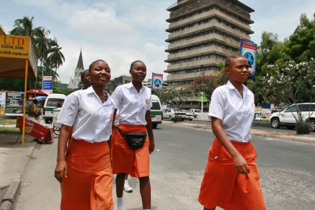 Girls walk along a street in Dar es Salaam, Tanzania