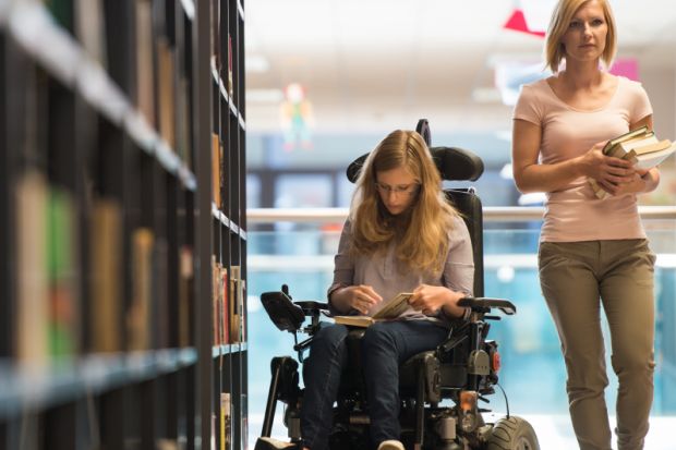 Woman in wheelchair in library