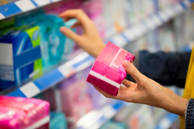 Woman choosing feminine hygiene products in supermarket